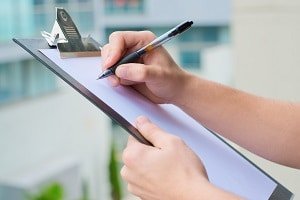 Person Checking Off Items On Clipboard
