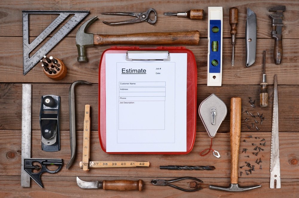 High angle shot of a contractors estimate form surrounded by his well used tools.